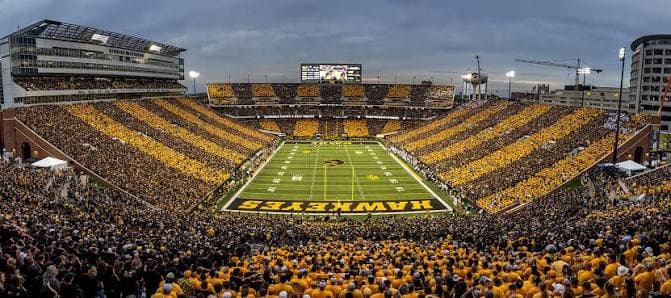 Kinnick Stadium striped in black and gold — the full-bowl stripe-out with the HAWKEYES end zone front and center