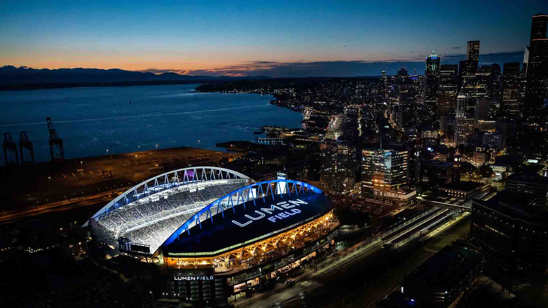 A general view of Lumen Field packed with Seattle Seahawks fans on game day, the 12 flag flying over the open north end with the downtown skyline behind