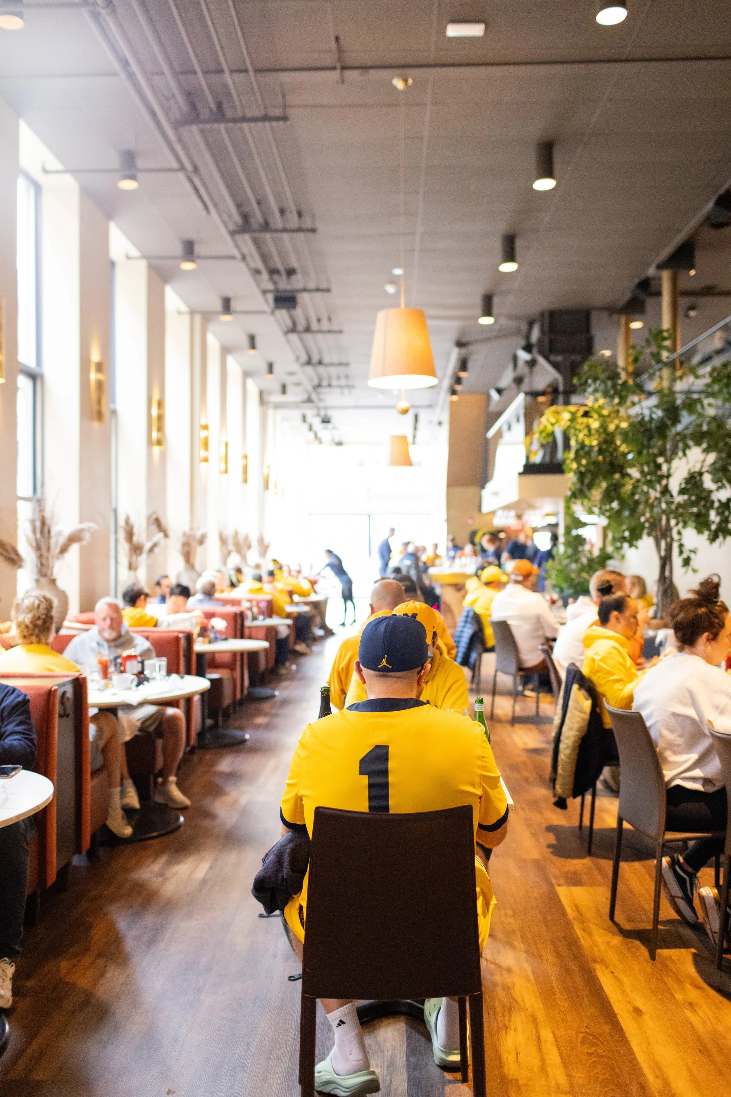 A packed dining room at Sava's full of Michigan fans in maize and blue on a game-day morning