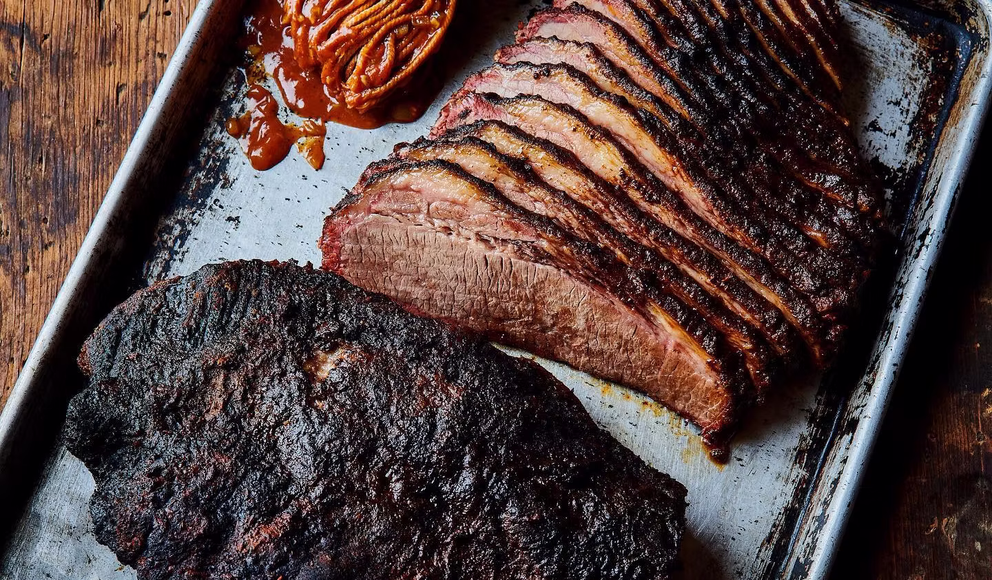 A tray of sliced and chopped brisket with barbecue sauce at Bow & Arrow