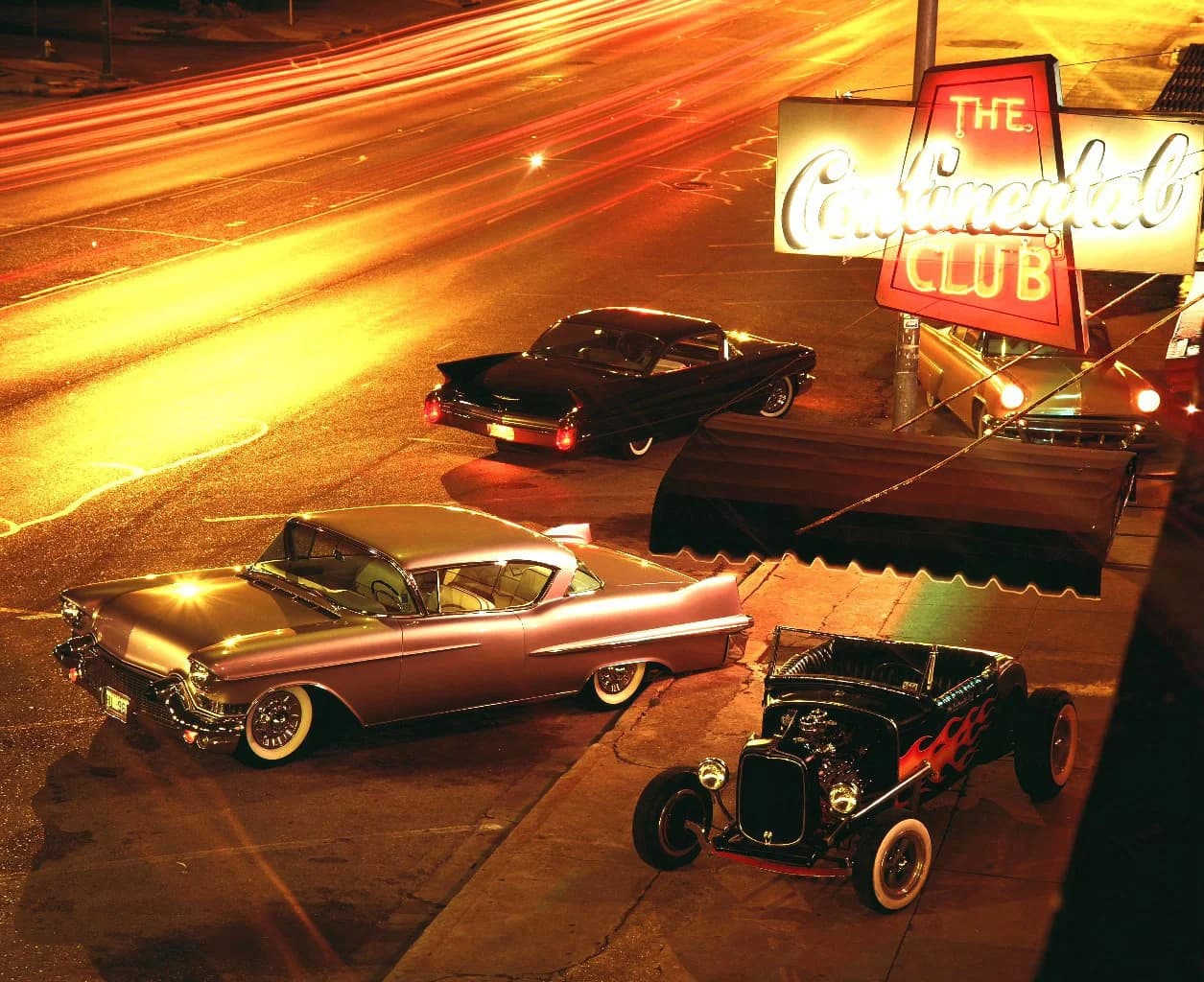 The Continental Club's red neon sign lit up at night on South Congress, vintage cars parked out front