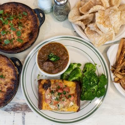 An overhead spread at Elsie's Plate & Pie — hand pies, gumbo, cracklins, and a green-plate special with greens and cornbread