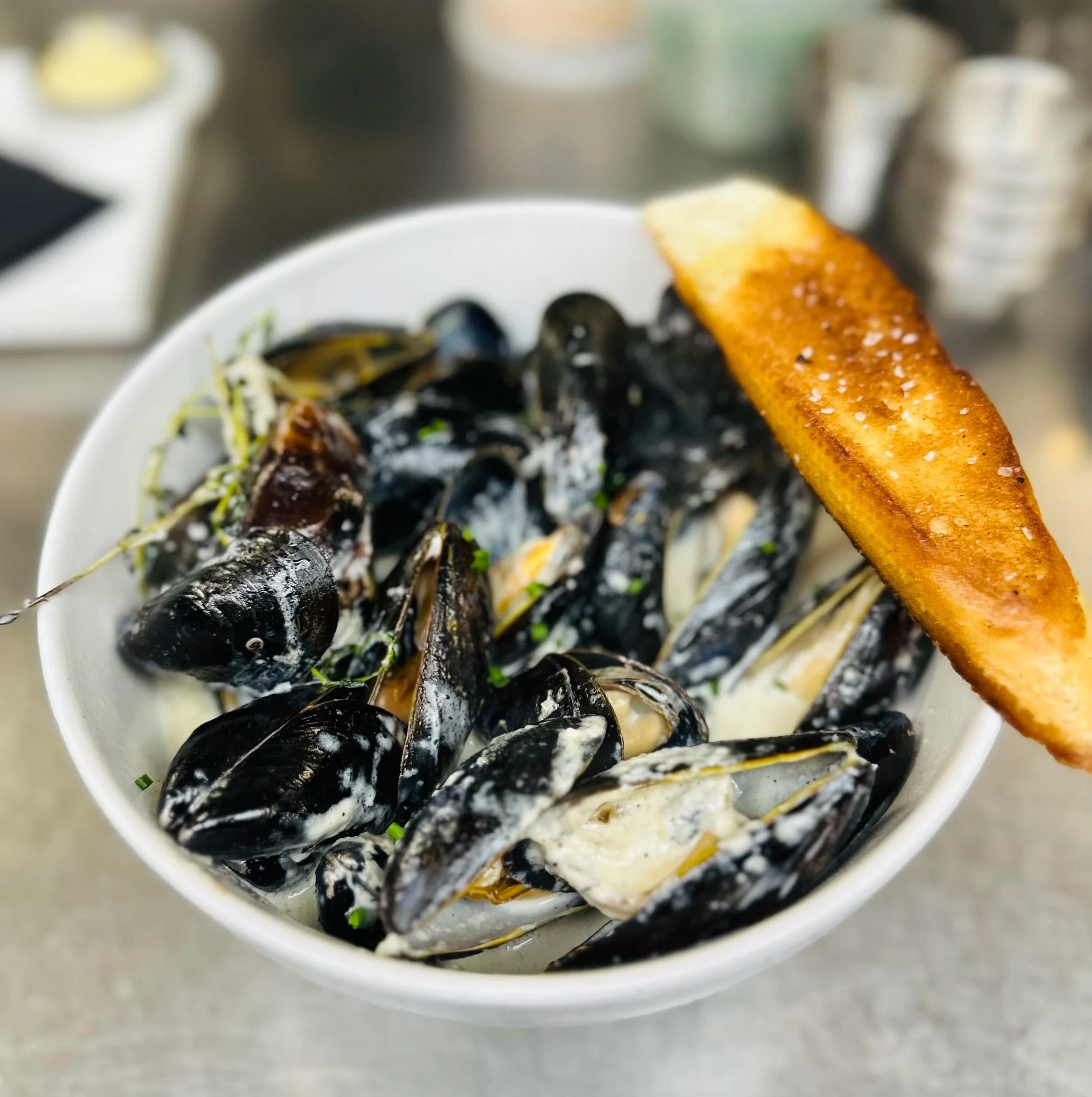 A bowl of creamy mussels with a grilled crostini at Public Fish & Oyster