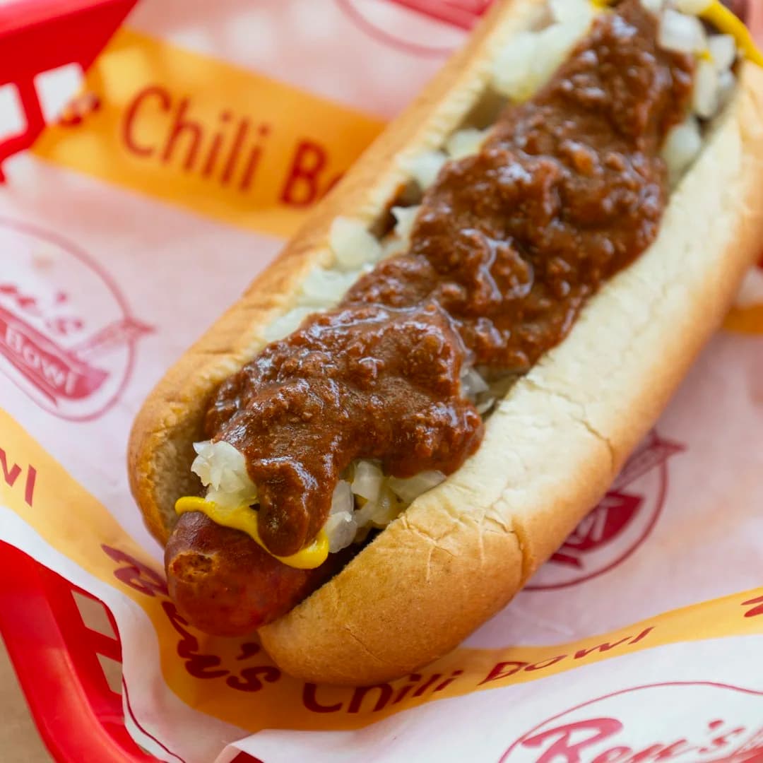 A half-smoke loaded with chili, mustard, and onions in a Ben's Chili Bowl basket