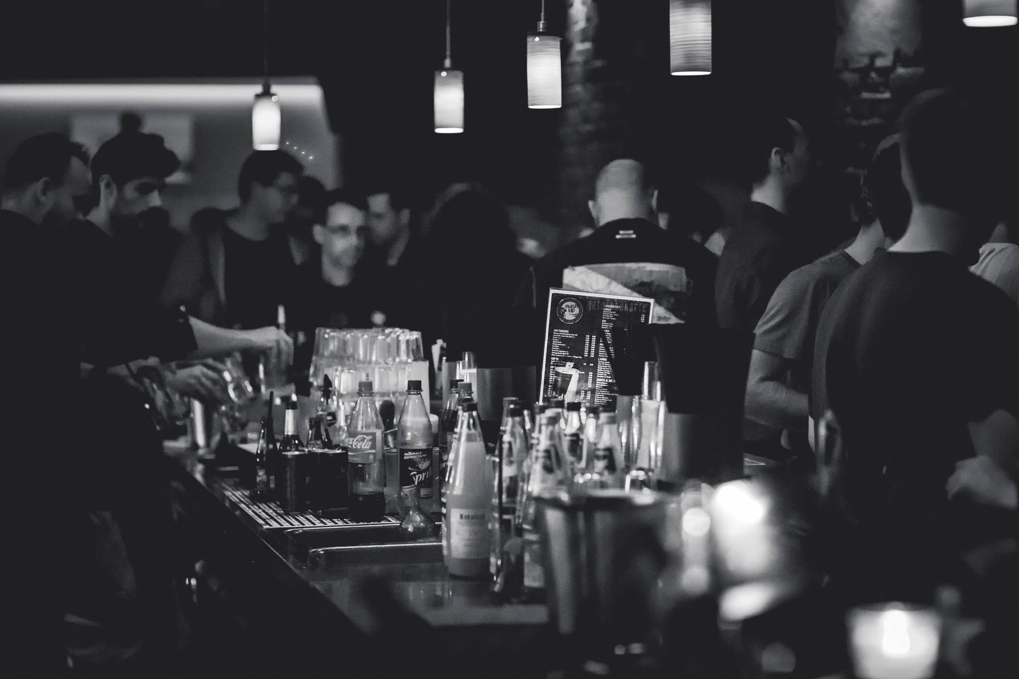 A crowded night at Son of a Gun's bar, patrons gathered under pendant lights