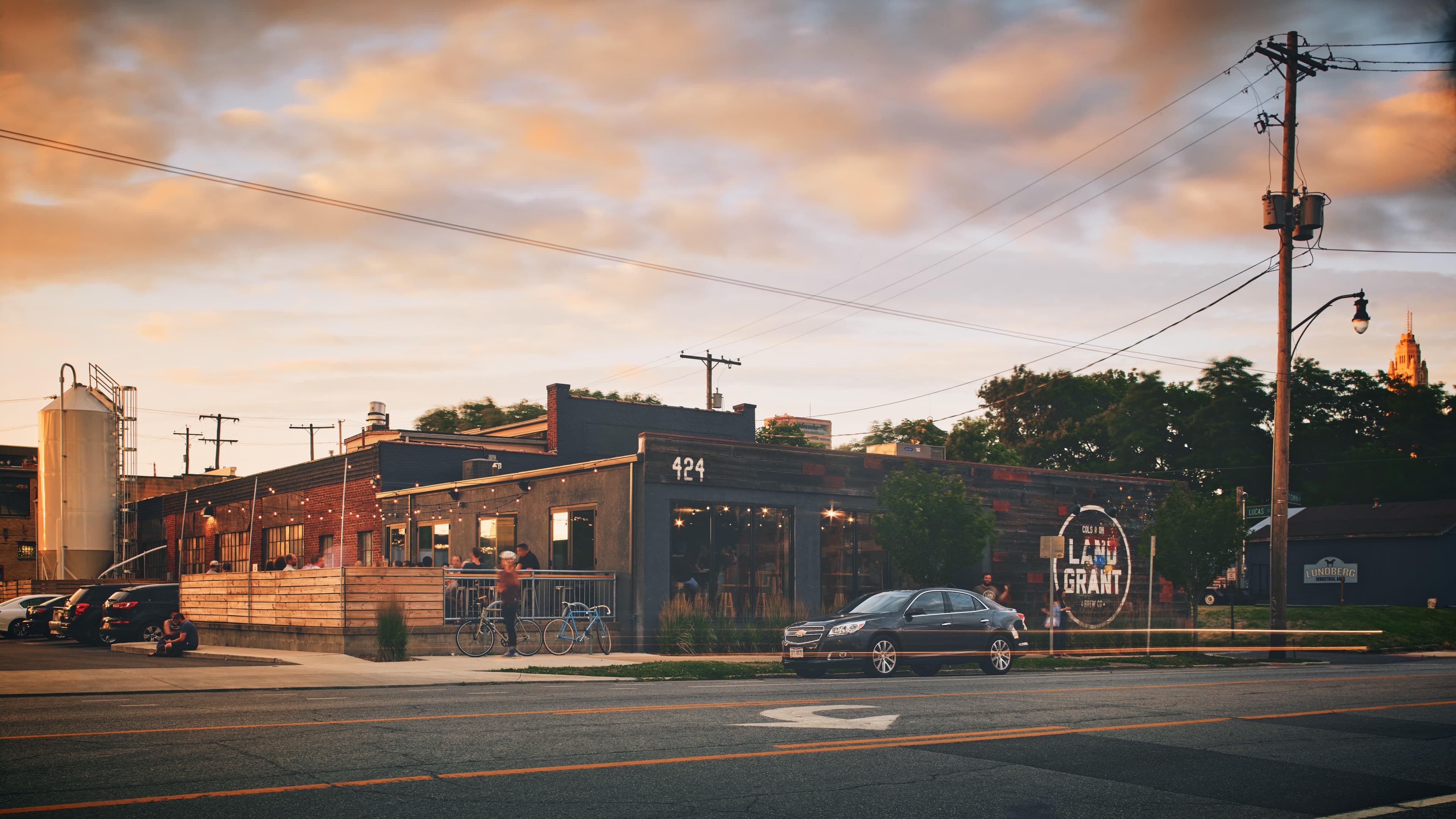 Land-Grant Brewing's converted industrial building and string-lit patio glowing at sunset