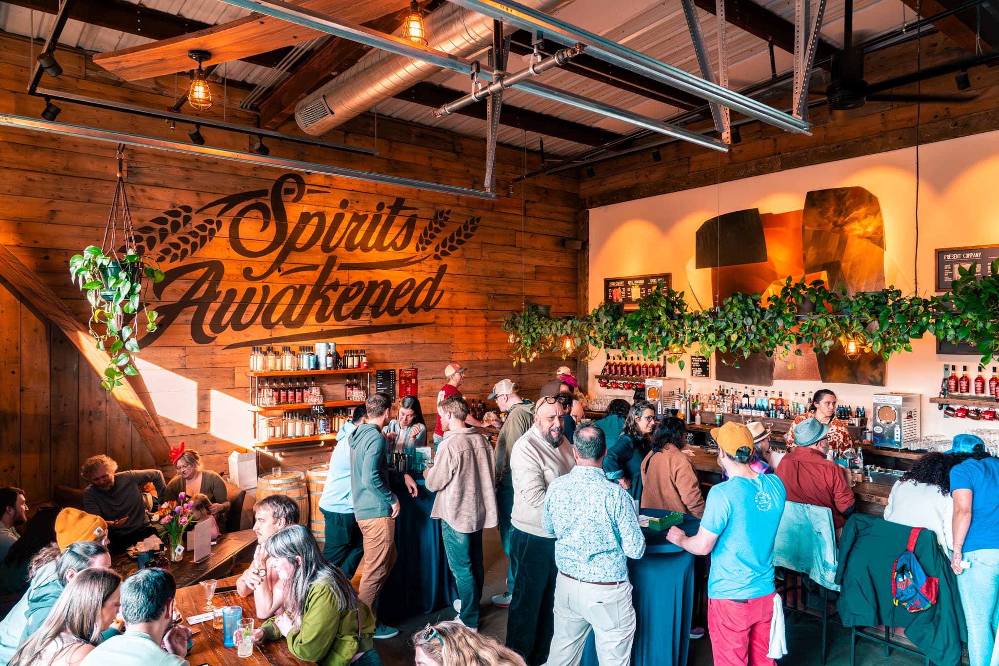 A packed tasting room crowd beneath the wood-burned \