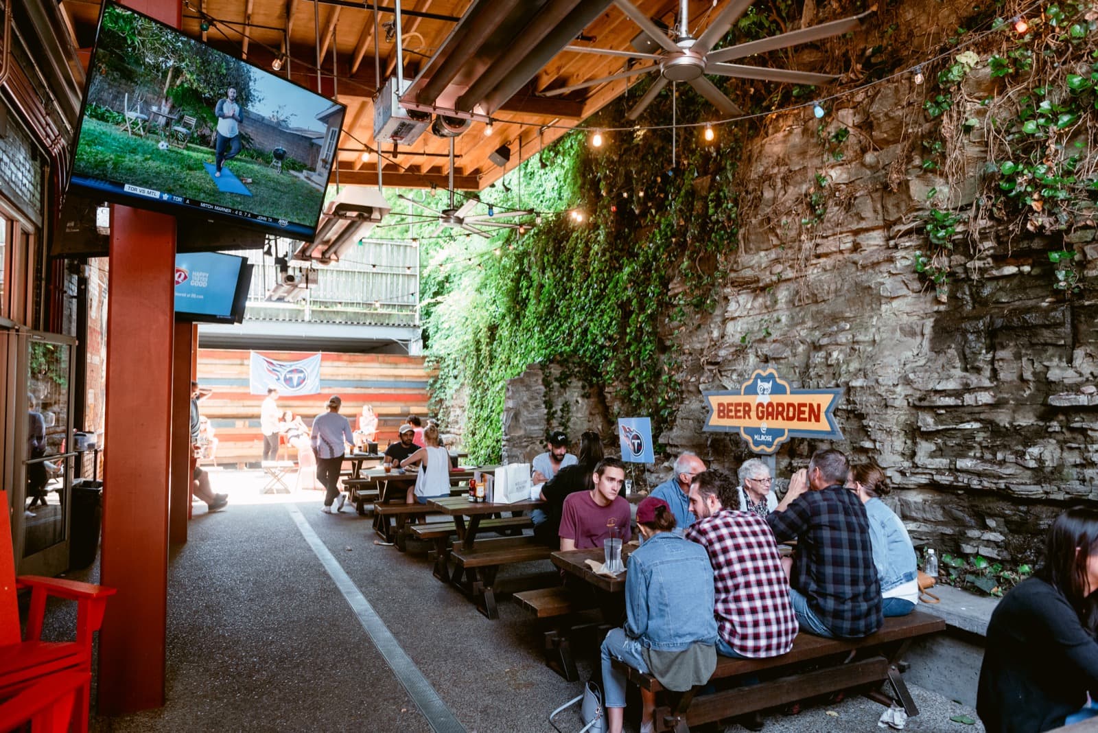 M.L. Rose's limestone-walled beer garden patio, string lights overhead and picnic tables full of fans watching TVs