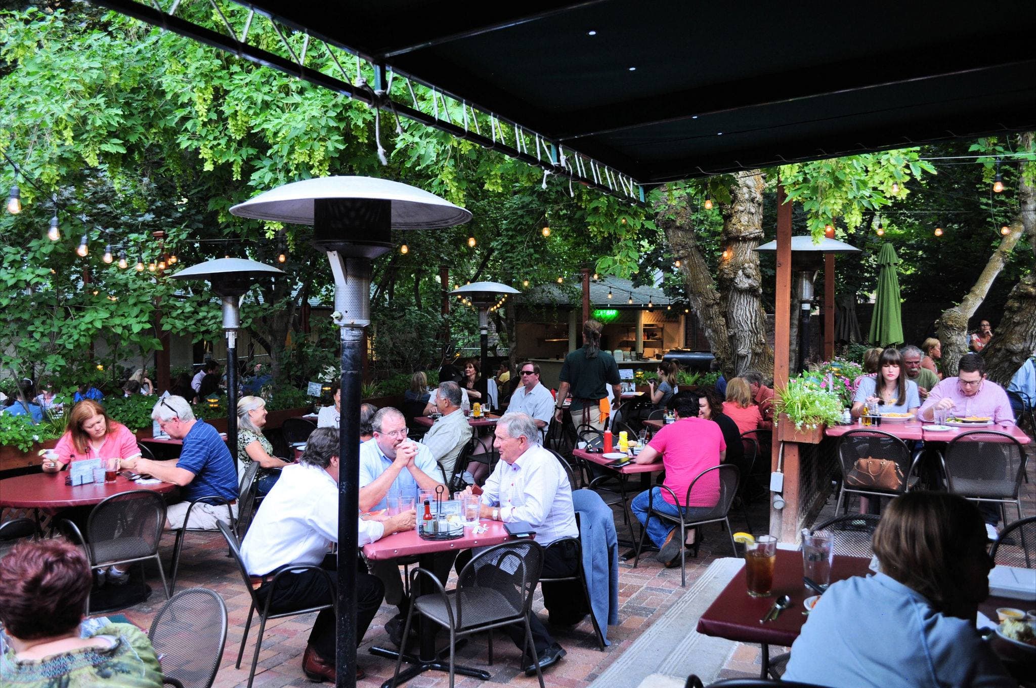 A packed shaded patio full of diners at Ruth's Diner, string lights overhead and greenery all around