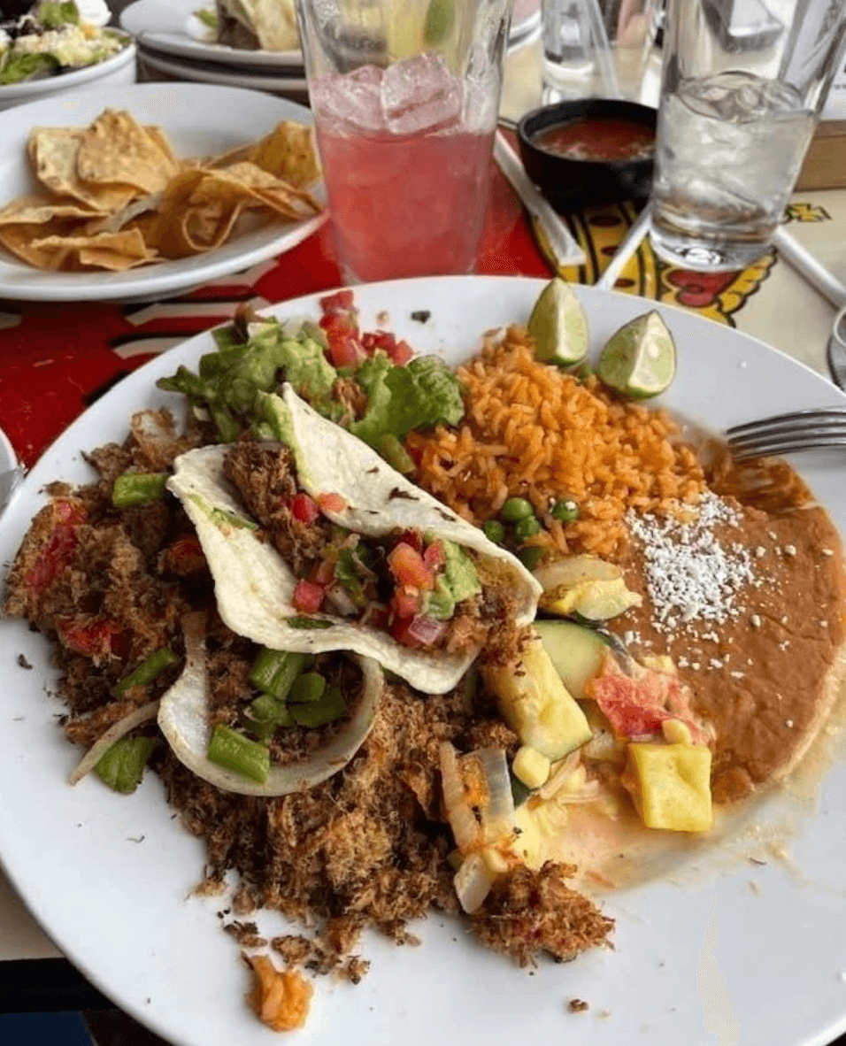 A shredded beef taco plate with guacamole, Mexican rice, and refried beans at El Charro Café