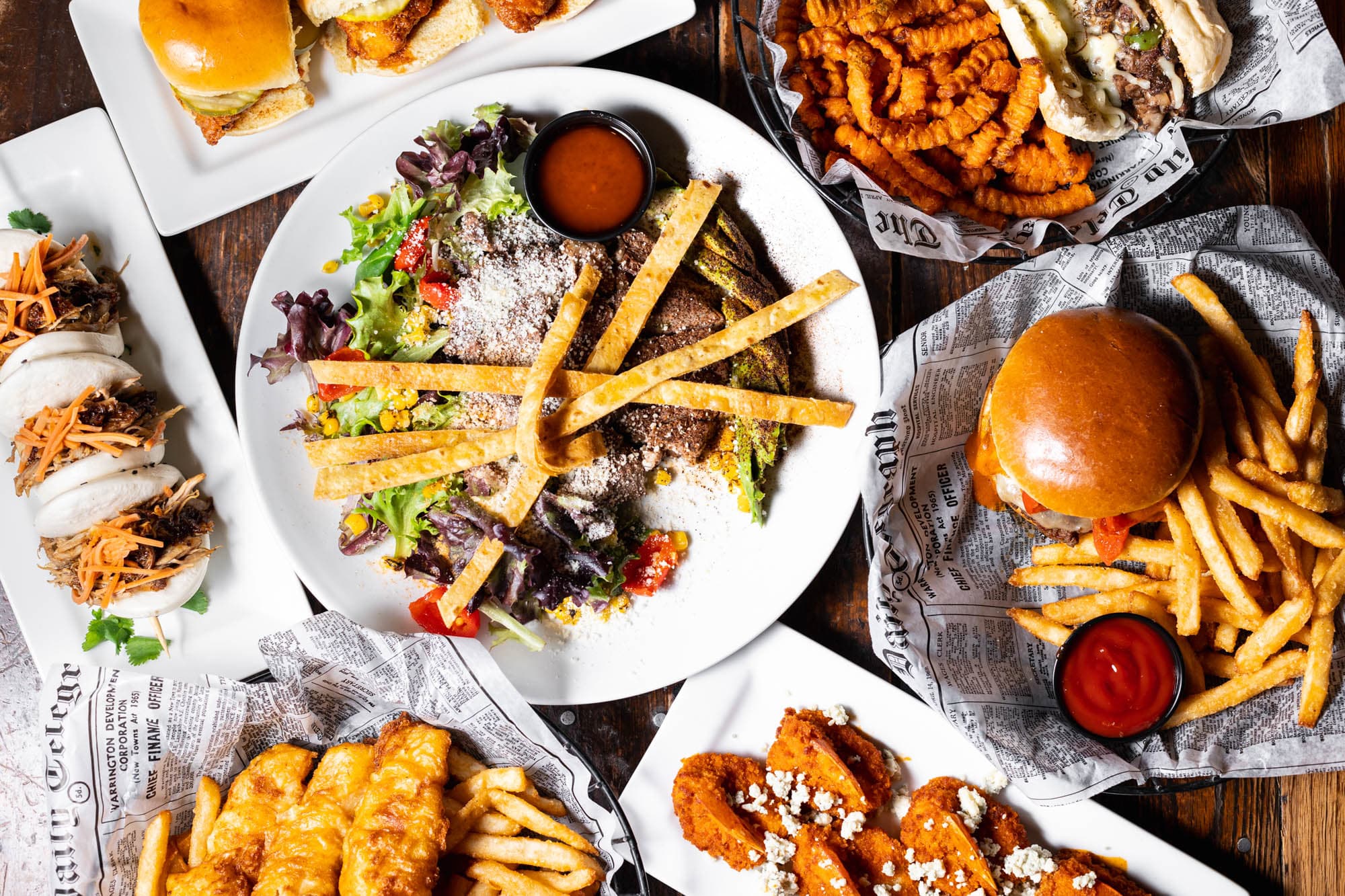 A spread of burgers, fries, pork buns, buffalo wings and fried fish and chips at Digby's Pub & Patio