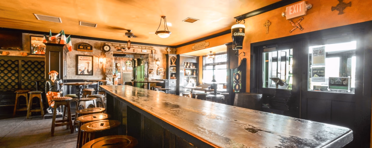 Nine Irish Brothers' pub interior with a fresh pint of Guinness on the bar and Irish memorabilia on the walls
